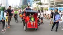 Seorang Warga Negara Asing mengendarai becak saat Hari Bebas Kendaraan di Kawasan Bundaran HI, Minggu (7/5). Aksinya ini sempat menarik perhatian warga. (Liputan6.com/Helmi Fithriansyah)