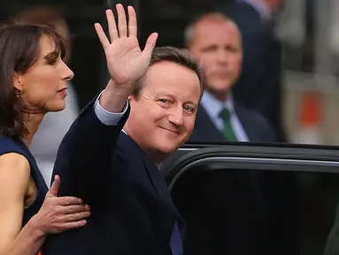 PM Inggris David Cameron didampingi istri, Samantha melambaikan saat akan meninggalkan kantornya, 10 Downing Street, London, Rabu (13/7). David Cameron mundur dari jabatannya sebagai PM Inggris pasca referendum Uni Eropa. (AFP PHOTO/Geoff Caddick)