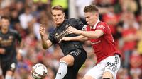 Gelandang Manchester United Scott McTominay (kanan) bersaing dengan Martin Odegaard dari Arsenal dalam pertandingan Liga Inggris di Old Trafford, Manchester, 4 September 2022. (Oli SCARFF/AFP)