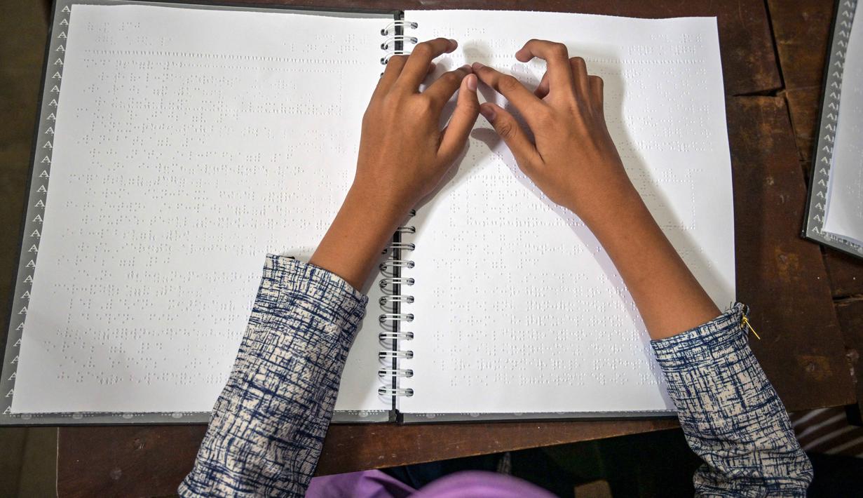 Seorang siswa tunanetra membaca Al-Quran dalam huruf Braille selama bulan suci Ramadan 1447 Hijriah di sebuah sekolah di Surabaya, Jawa Timur, pada 27 Februari 2026. (JUNI KRISWANTO/AFP)