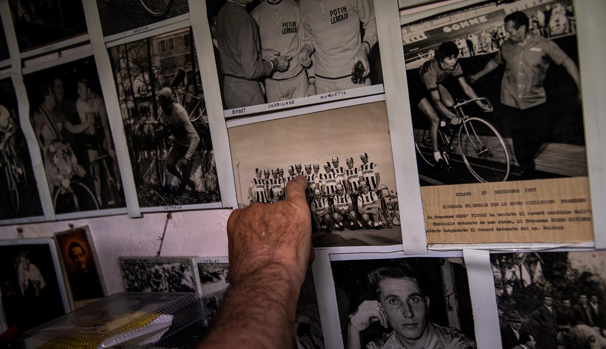 Raffaello Bianco, mekanik dan pecinta sepeda bekerja menunjukkan gambar tim pro tahun 1950-an-60an "Carpano" di bengkel mekaniknya di ruang bawah tanah apartemennya di Turin, Italia, 7 Juli 2020. Bianco mengatakan selalu memiliki gairah yang lebih besar terhadap sepeda. (MARCO BERTORELLO/AFP)