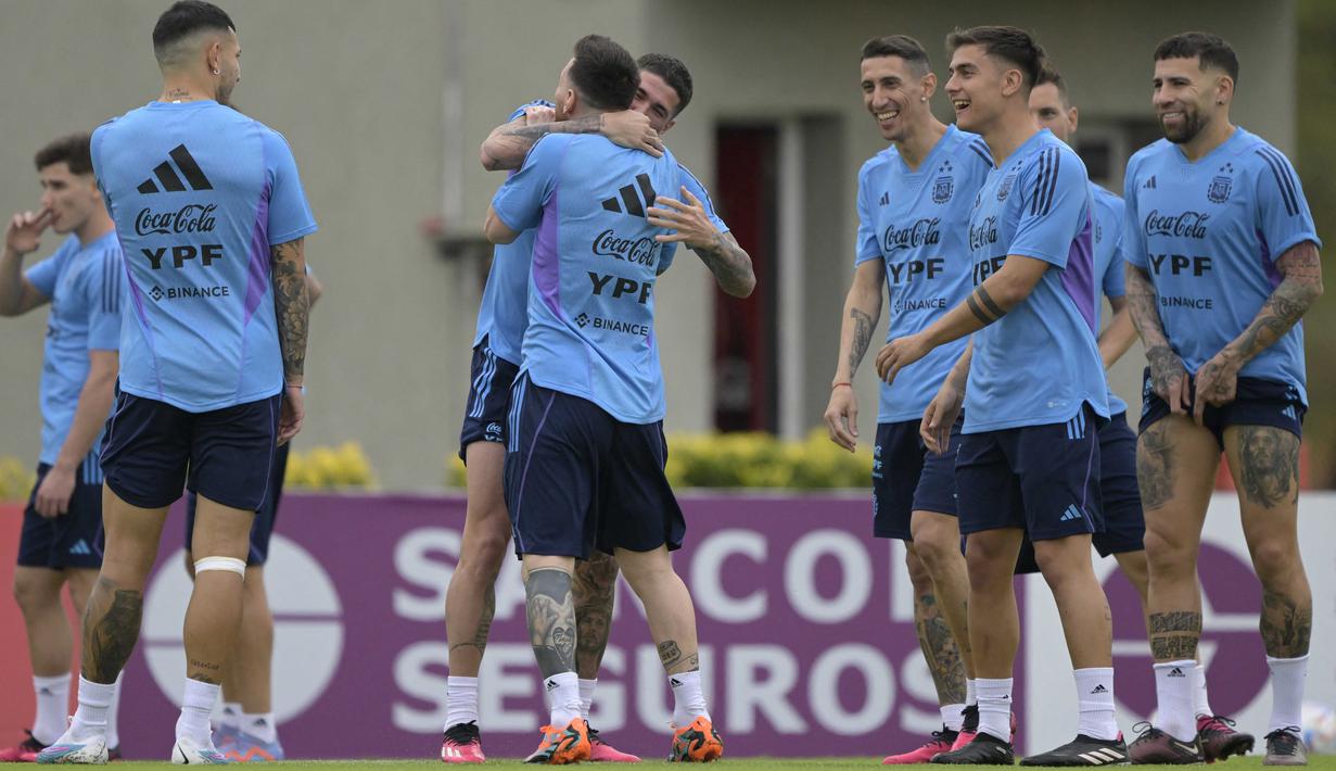 Pemain timnas Argentina Rodrigo De Paul (tengah) yang baru saja tiba langsung memeluk Lionel Messi dalam sesi latihan di Kamp Pelatihan Julio Humberto Grondona, Ezeiza, Argentina, Rabu (21/3/2023). (AFP/Juan Mabromata)