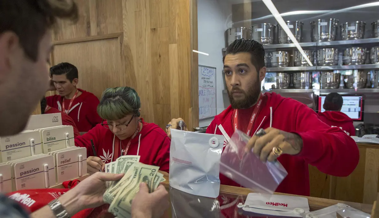 Pelanggan membayar produk ganja yang ia beli di MedMen, salah satu dari dua toko pot daerah Los Angeles yang mulai menjual ganja di West Hollywood, California (2/1). (David McNew / Getty Images / AFP)
