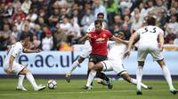 Pemain Manchester United, Henrikh Mkhitaryan berusaha keluar dari kepungan para pemain Swansea City pada lanjutan Premier League di Liberty Stadium, Swansea, (19/8/2017). (Nick Potts/PA via AP)