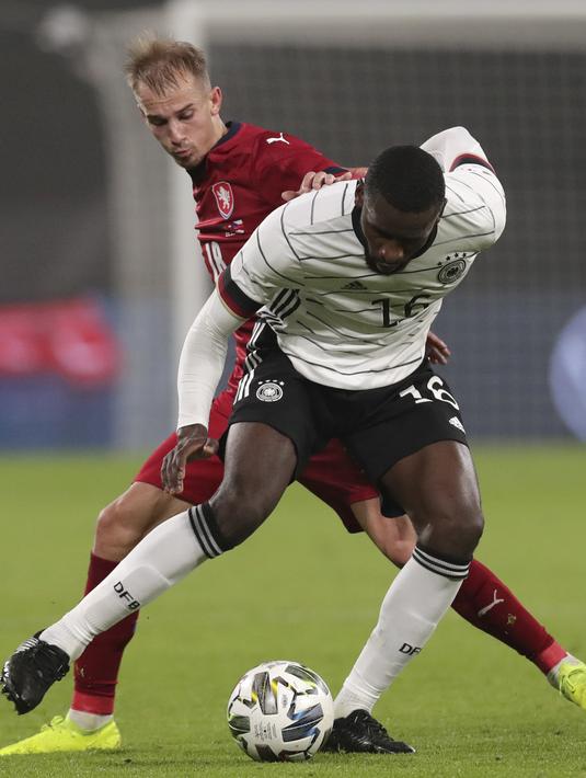Penyerang Republik Ceko, Vaclav Cerny berebut bola dengan bek Jerman, Antonio Rudiger dalam laga persahabatan di Red Bull Arena, Leipzig, Kamis (12/11/2020) dini hari WIB. Jerman sukses mengalahkan Republik Ceko dengan skor tipis 1-0. (AP Photo/Michael Sohn)