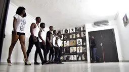 Wanita dan pria muda ikut serta dalam pelatihan catwalk di agen model Fatim Sidime di Abidjan, Pantai Gading (20/12). Mereka mengikuti pelatihan karena industri fashion dan model di Afrika terus mengalami perkembangan. (AFP Photo/Sia Kambou)