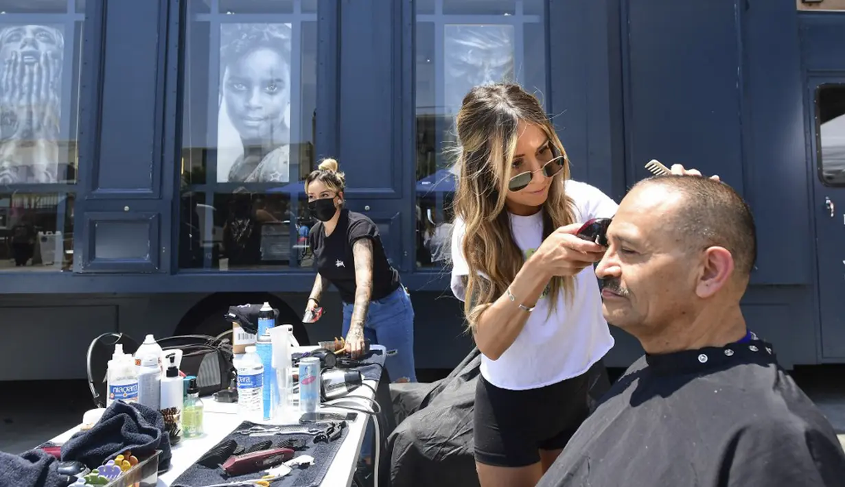 Abel Macias menerima potongan rambut baru dari stylist Michelle London saat cukur rambut gratis untuk para tunawisma dalam Los Angeles Mission di Los Angeles, California, Amerika Serikat, 12 Juli 2021. (Frederic J. BROWN/AFP)
