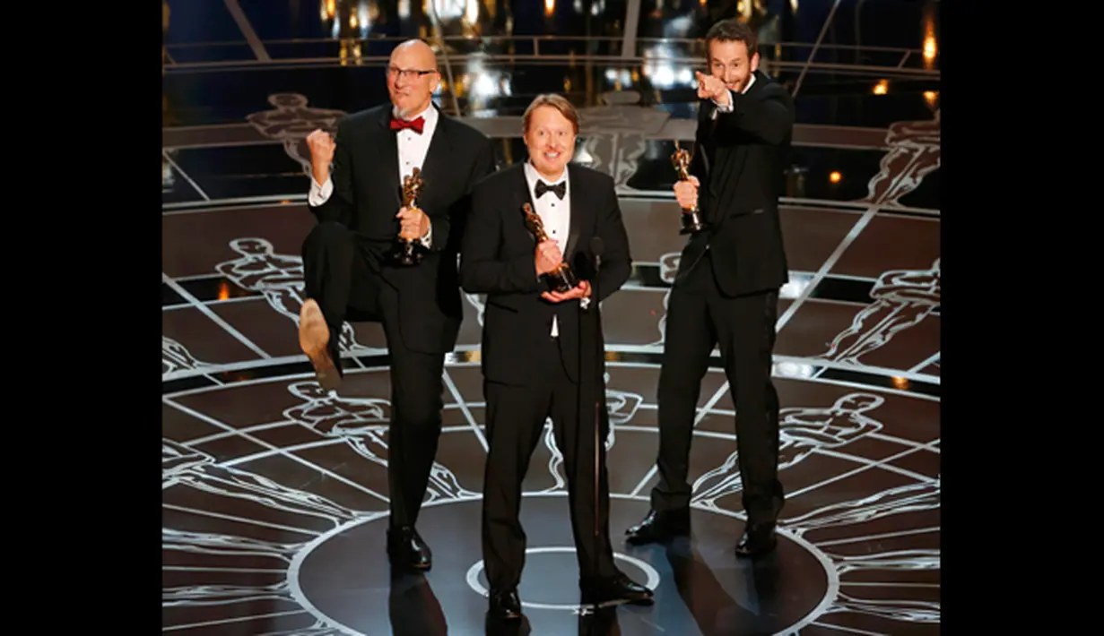 Roy Conli, Don Hall, dan Chris Williams, (kiri ke kanan) menerima piala Oscar untuk film animasi terbaik  dalam film "BIG HERO 6," di Academy Awards ke-87 di Dolby Theatre, Los Angeles, California, (22/2/2015). (Reuters/Mike Blake)