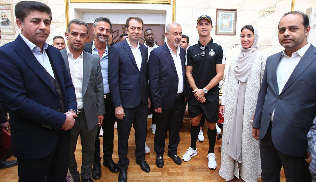 Pemain Al-Nassr, Cristiano Ronaldo (ketiga kanan) berfoto bersama dengan ofisial setibanya di Imam Khomeini International Airport, Tehran menjelang laga Liga Champions Asia 2023 melawan Persepolis FC, Selasa (19/09/2023). (AFP/Persepolis FC)