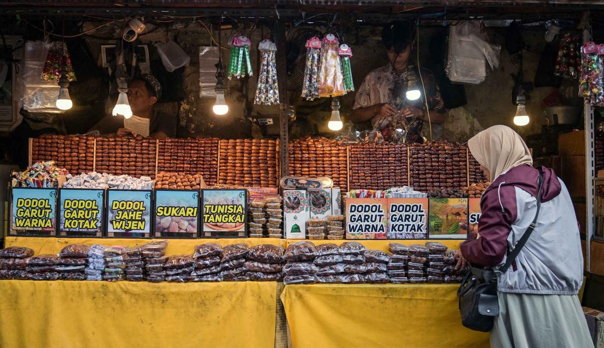 Terletak di jalan utama menuju Masjid Sunan Ampel, menciptakan suasana ngabuburit yang religius dan ramai pengunjung. Tampak dalam foto, seorang wanita muslim membeli kurma selama bulan suci Ramadan di dekat Masjid Sunan Ampel, Surabaya, Jawa Timur, pada Minggu 8 Maret 2026. (JUNI KRISWANTO/AFP)