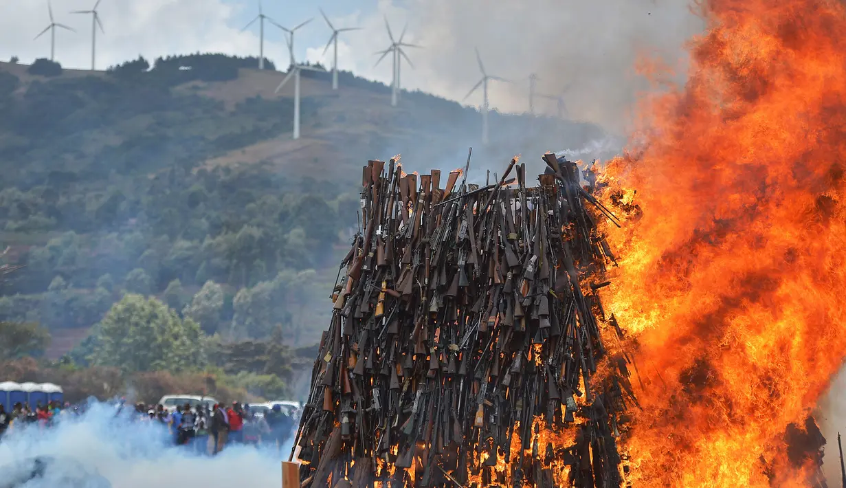 Api menyala besar saat ratusan senjta ilegal dibakar di di Kajiado County, Kenya (15/11). Karena maraknya penggunaan senjata api, tingkat perburuan satwa liar meningkat tajam di Kenya. (AFP/Tony Karumba)