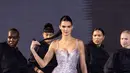 Kendall Jenner sebagai  wajah baru merek kosmetik ikonik Prancis menutup pertunjukan dengan runway walk teatrikal. Tampil mencolok dalam balutan gaun berwarna perak berkilauan dari Ludovic de Saint Sernin, ia diapit oleh para penari berpakaian serba hitam yang menari-nari di sekelilingnya. [@@kendalljbr]