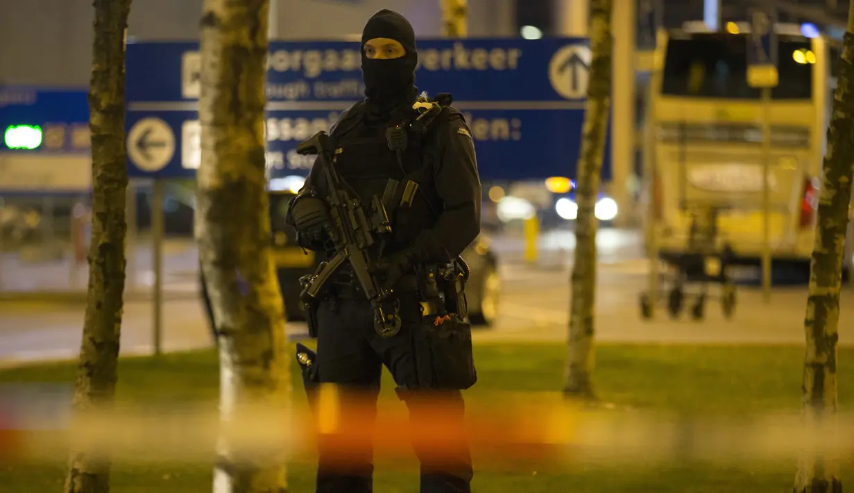 Seorang pasukan bersenjata berjaga di area Bandara Internasional Schiphol, Amsterdam, yang ditutup menyusul ancaman bom, Selasa (12/4).  Pihak kepolisian menangkap seorang pria dengan perilaku mencurigakan terkait ancaman bom. (Michel van Bergen/ANP/AFP)