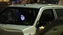 Wanita membaca Al-Quran dalam mobil saat upacara keagamaan pada bulan suci Ramadan di tengah pandemi COVID-19, Teheran, Iran, Kamis (30/4/2020). Keluarga-keluarga di Iran menghadiri upacara keagamaan drive-in karena tidak memiliki kesempatan untuk salat di masjid setelah berbuka puasa. (STR/AFP)