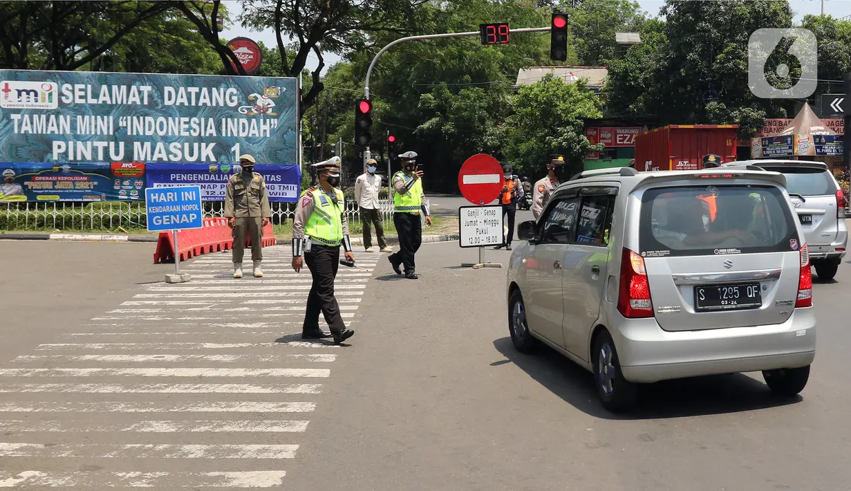 Polisi mengatur lalu lintas saat pengendalian mobilitas ganjil genap untuk pengunjung TMII di Jalan Pintu 1 TMII, Jakarta, Sabtu (18/9/2021). Pembatasan mobilitas pada TMII dan Taman Impian Jaya Ancol dilakukan pada hari Jumat-Minggu mulai pukul 12.00-18.00 WIB. (Liputan6.com/Herman Zakharia)