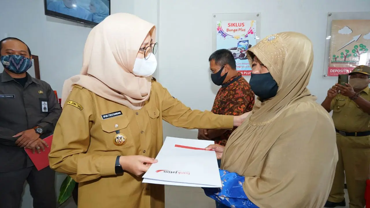 Bupati Banyuwangi Ipuk Fiestiandani menyerahkan bantuan tunai dari Pemprov Jatim. (Dian Kurniawan/Liputan6.com)
