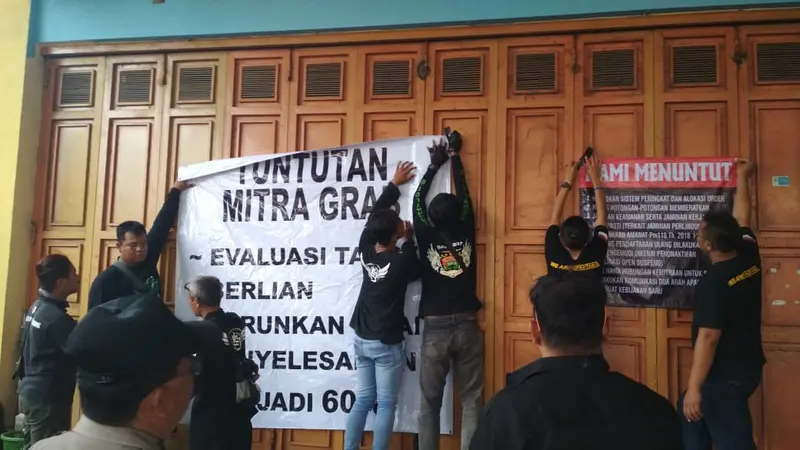 Pengemudi Gojek dan Grab menyegel kantor di Purwokerto, protes agar tuntutannya dipenuhi. (Foto: Liputan6.com/Nanang Supriyadi untuk Muhamad Ridlo)