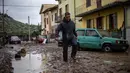 Seorang pria berjalan di lumpur di Montemurlo setelah hujan deras, pada 3 November 2023. (Federico SCOPPA/AFP)