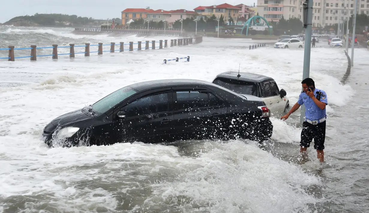 Sejumlah mobil saat dihantam ombak besar yang disebabkan Topan Yagi di sepanjang pantai laut di Qingdao di provinsi Shandong timur China, (13/8). Menurut Kantor Berita Xinhua, Topan Yagi memiliki kecepatan hingga 102 kilometer per jam. (AFP Photo)