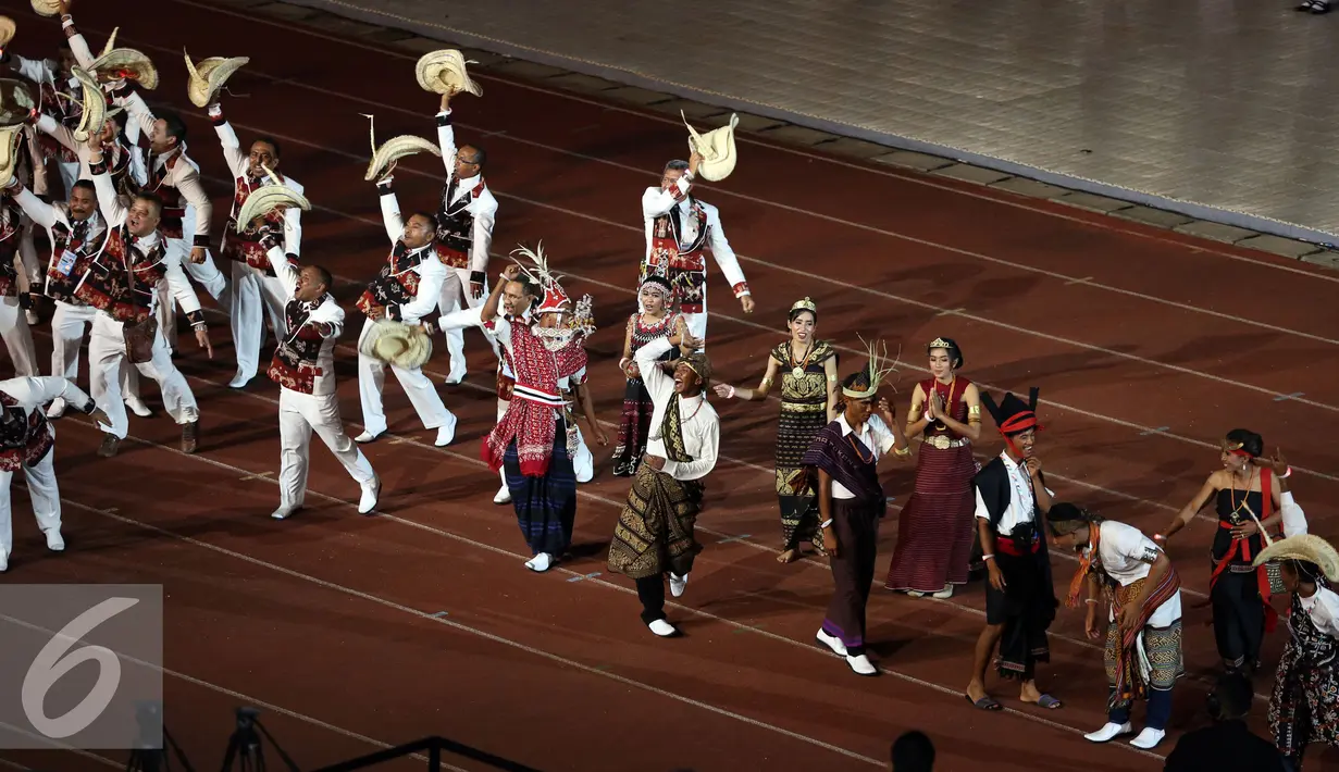 Kontingen Nusa Tenggara Timur menari saat mengikuti defile peserta PON XIX Jabar di Stadion Gelora Bandung Lautan Api, Bandung, Sabtu (17/9). 9.533 atlet akan berlaga di 44 cabang olahraga. (Liputan6.com/Helmi Fithriansyah)