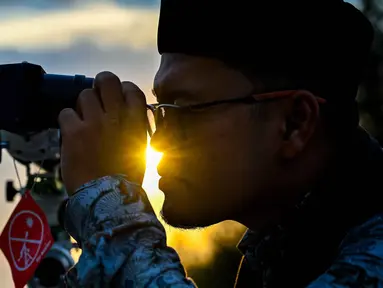Seorang petugas observatorium mengamati bulan, menjelang Idul Fitri sekaligus menandai berakhirnya bulan suci Ramadan1447 Hijriah melalui teleskop di kantor observatorium, pantai Lhoknga, Aceh pada Kamis 19 Maret 2026. Salah satu metode dalam menentukan awal bulan Hijriah, umat Islam menggunakan rukyat hilal. (CHAIDEER MAHYUDDIN/AFP)