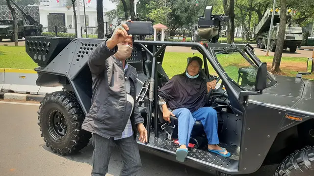 Warga berfoto di lokasi pameran alutsista di sekitaran Istana Merdeka dalam rangka HUT ke-76 TNI, Selasa (5/10/2021). (Liputan6.com/ Ady Anugrahady)