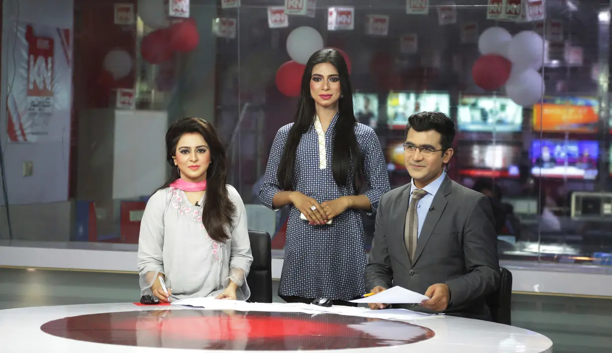Marvia Malik, pembawa berita transgender pertama di Pakistan, dan rekan-rekannya sebelum membacakan berita untuk saluran televisi Kohenoor di Lahore, Selasa (27/3). Malik menjadi presenter setelah mendapat pelatihan selama tiga bulan. (AP/K.M. Chaudary)