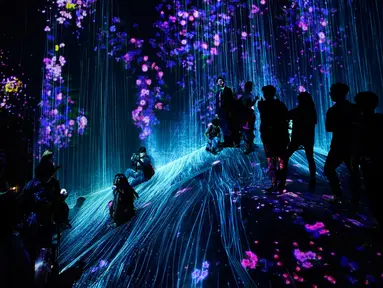 Pengunjung menyaksikan instalasi digital yang menampilkan proyeksi air terjun dan bunga di Museum Seni Digital Mori Building, Tokyo, 21 Juni 2018. Museum seluas 10.000 meter persegi ini banyak menampilkan seni digital mengagumkan. (AP/Shuji Kajiyama)