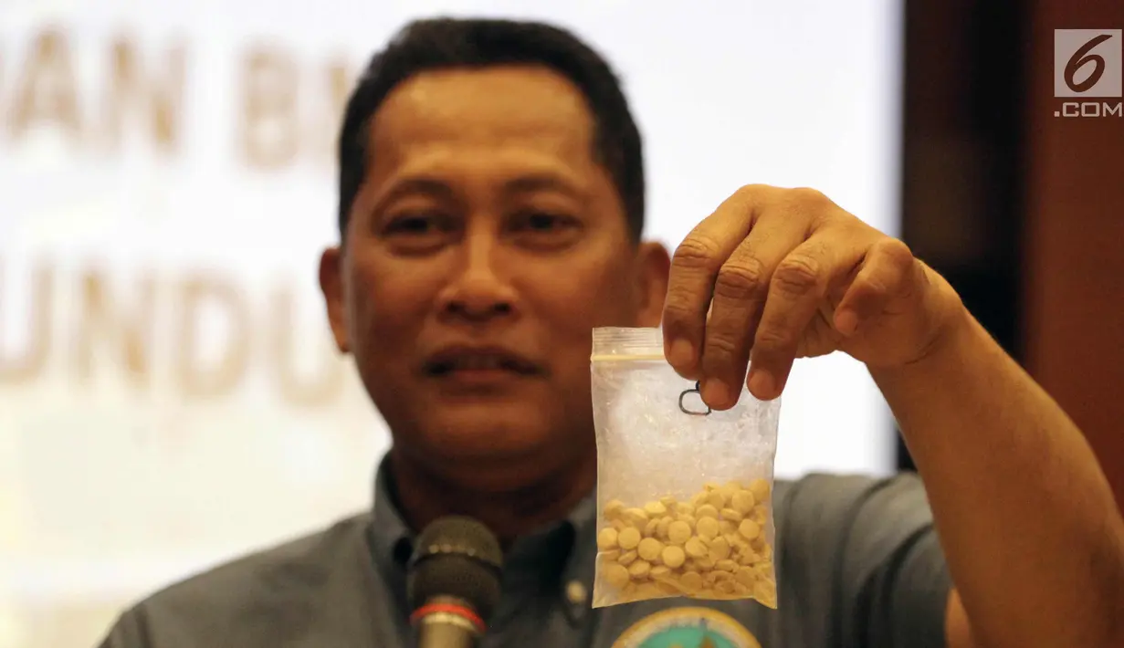 Kepala BNN Budi Waseso menunjukan barang bukti ekstasi saat rilis di Kemenkeu, Jakarta, Rabu (7/1). BNN mengamankan 12 orang tersangka berserta barang bukti sebanyak 110,84 kilogram sabu dan 18.300 butir ekstasi. (Liputan6.com/Arya Manggala)