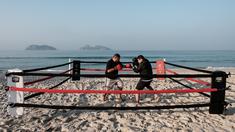  Pelatih tinju, Moacyr Lima (kiri), melatih Leandro Guignoni di ring tinju yang terletak di Pantai Pepe, Rio de Janeiro, Brasil, (26/7/2016). (AFP/Yasuyoshi Chiba)