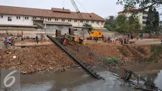 Crane untuk memasang turap di bantaran Kali Kampung Pulo jatuh ke Sungai Ciliwung (1/10/15) dan menimpa gubuk. Akibatnya, seorang warga RT15/10 Kelurahan Bukit Duri, Jakarta Selatan harus mendapatkan perawatan medis. (Liputan6.com/Gempur M Surya)