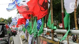 Pemasangan bendera partai politik di pagar pembatas sangat membahayakan keselamatan pengguna jalan. (Liputan6.com/Herman Zakharia)