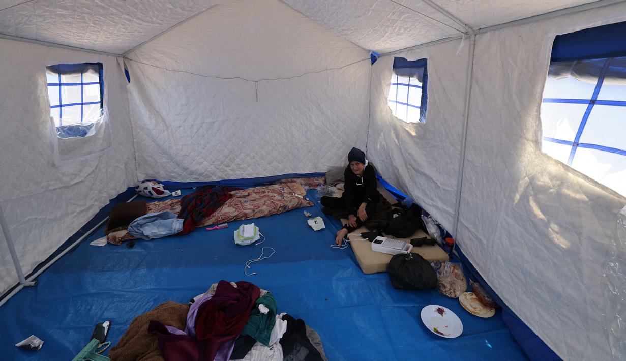 Seorang wanita Lebanon lanjut usia yang mengungsi duduk di dalam salah satu tenda biru yang didirikan pemerintah untuk orang-orang yang meninggalkan rumah dan desa mereka di pinggiran selatan Beirut dan Lebanon Selatan, Jumat 22 Mei 2026. (Anwar AMRO/AFP)