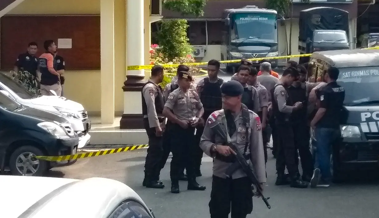 Polisi berjaga setelah pelaku bom bunuh diri meledakkan dirinya di Mapolrestabes Medan, Sumatera Utara, Rabu (13/11/2019). Area Mapolrestabes Medan dijaga ketat aparat kepolisian bersenjata lengkap. (Rahmad SURYADI/AFP)