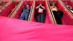Sejumlah pemuja berdoa saat mereka berbaring dalam peti mati di kuil Takien, pinggiran kota Bangkok, Thailand, Senin (31/12). Upacara agama ini sebagai bagian dari ritual untuk menerima kematian yang tidak bisa dihindari manusia. (AP/Sakchai lalit)