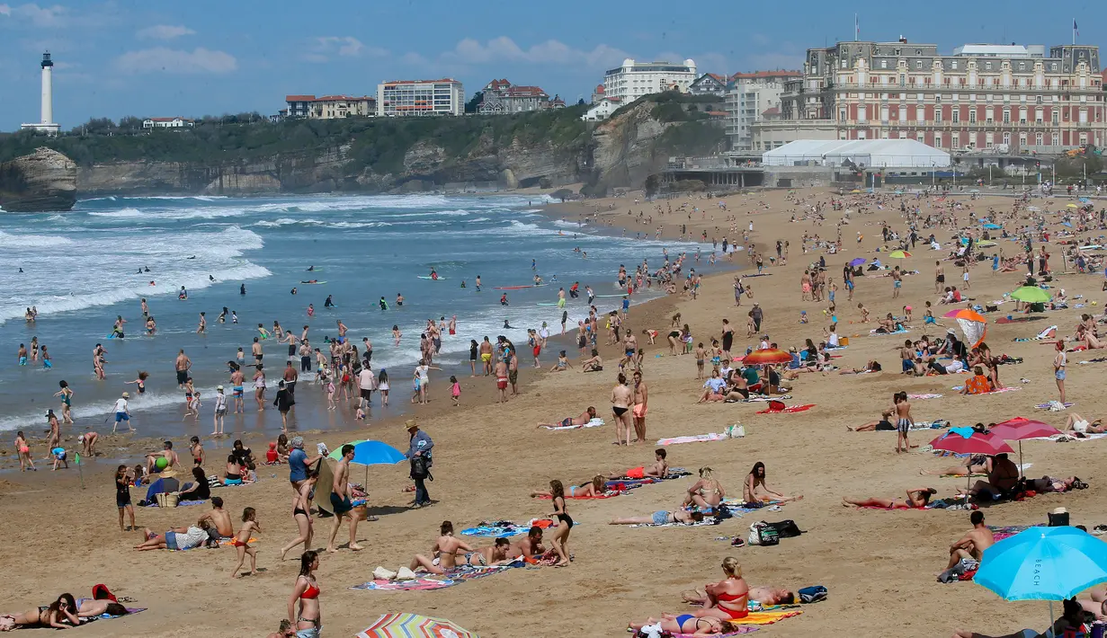 Orang-orang berjemur di pantai Biarritz, Prancis, Kamis (19/4). Masyarakat Paris banyak mengisi musim semi dengan berjemur di pantai. (AP Photo/Bob Edme)