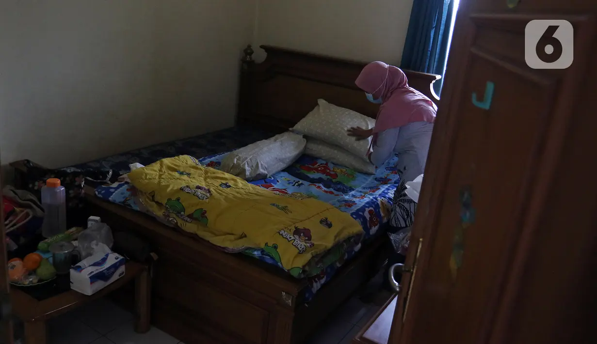 NY yang sedang melakukan isolasi mandiri karena terjangkit COVID-19 merapikan kasur di kediamannya, Rabu (10/2/2021). Dia kembali menekuni hobi lama: menjahit, merajut, dan menata ulang ruang kamarnya. (Liputan6.com/Herman Zakharia)