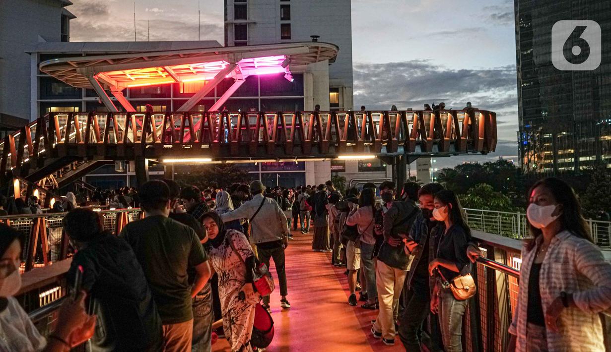 Warga berada di balkon Jembatan Penyeberangan Orang dan Sepeda (JPOS Phinisi) di kawasan Karet, Jakarta, Minggu (20/3/2022). JPOS Phinisi kini menjadi objek baru bagi warga Jakarta. (Liputan6.com/Faizal Fanani)