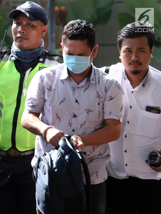 Kepala Kantor Imigrasi Kelas I Mataram Kurniadie (tengah) tiba di Gedung KPK, Jakarta, Selasa (28/5/2019). Kurniadie terjaring operasi tangkap tangan (OTT) KPK bersama tujuh orang lainnya. (Liputan6.com/HO/Joni)