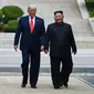 Presiden AS Donald Trump dan Pemimpin Korea Utara Kim Jong-un di sisi utara garis demarkasi militer, zona demiliterisasi Korea (DMZ), Panmunjom pada Minggu 30 Juni 2019 (Brendan Smialowski / AFP PHOTO)