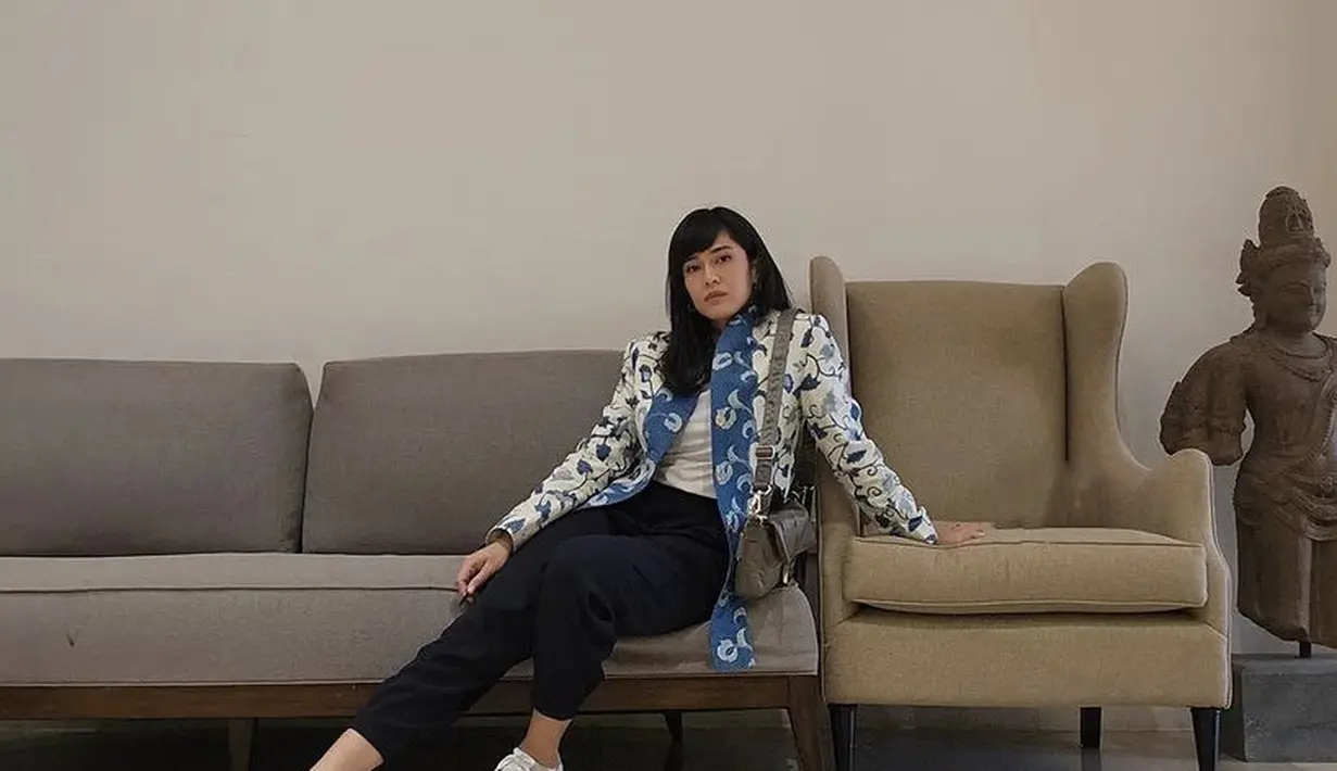 Dian Sastrowardoyo mengenakan blazer batik warna putih biru, dipadukan inner putih, celana panjang, dan sneakersnya. [@therealdisastr]