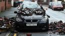 Sebuah mobil yang diparkir rusak terkena batu karena angin kencang yang disebabkan oleh atap apartemen yang runtuh di Leigh, barat laut Inggris, Rabu (18/11). (AFP PHOTO/Paul Ellis)