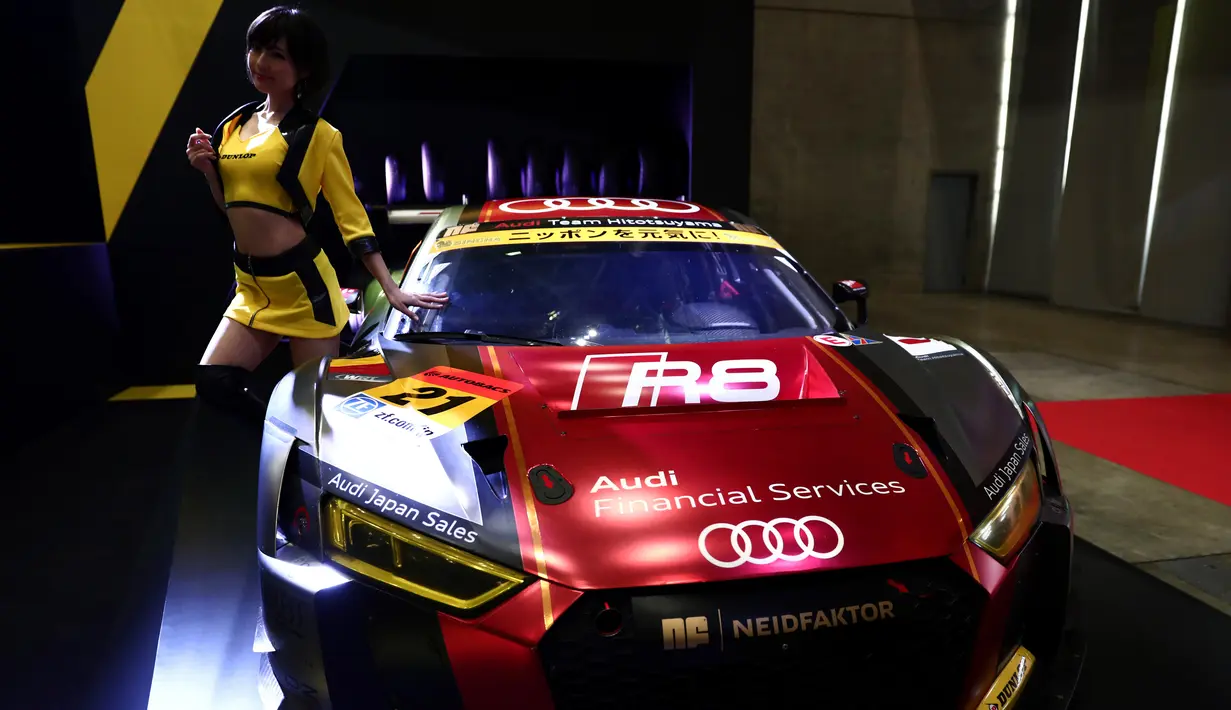 Seorang model berdiri di samping Audi R8 LMS selama Tokyo Auto Salon 2017 di Chiba, Jepang, Jumat (13/1). Tokyo Auto Salon 2017 menghadirkan berbagai produk otomotif keluaran terbaru serta mobil-mobil kustom teranyar. (AFP PHOTO/ BEHROUZ MEHRI)