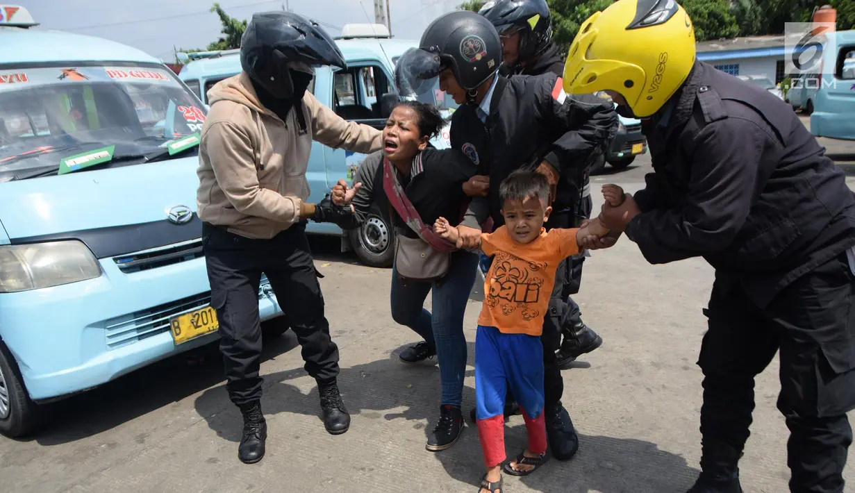 Seorang wanita dan anaknya terjaring razia oleh petugas Dinsos DKI di Kawasan Terminal Kampung Melayu, Jakarta, Jumat (11/5). Razia ini digelar karena maraknya PMKS musiman jelang bulan Ramadan. (Liputan6.com/Arya Manggala)