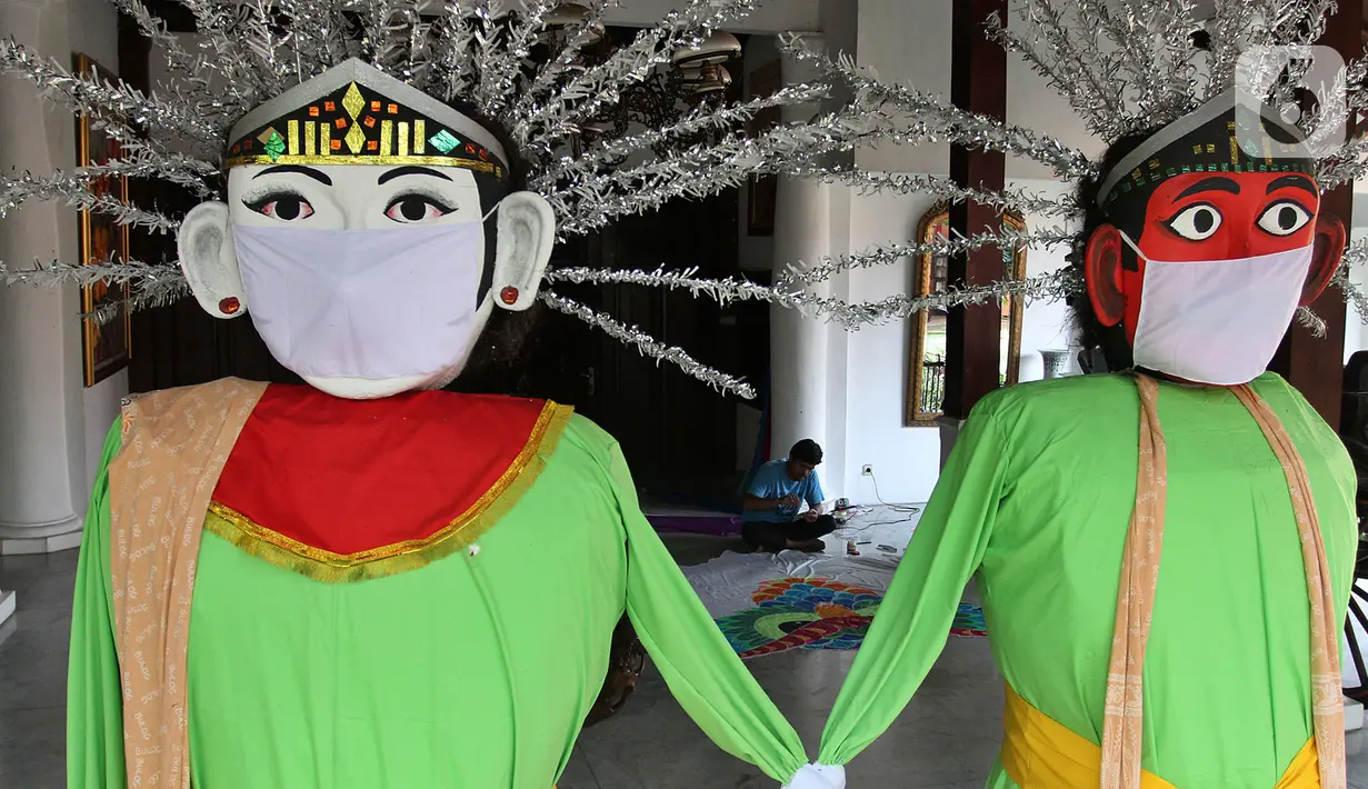 Sepasang onel-ondel bermasker menyambut pengunjung di Museum Layang-Layang, Kawasan Jakarta, Kamis (16/7/2020). Museum yang menampung 500 jenis layang-layang dari 32 provinsi itu kembali dibuka setelah tiga bulan tutup akibat pembatasan sosial berskala besar (PSBB). (merdeka.com/Arie Basuki)
