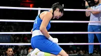 Petinju wanita Italia, Angela Carini, menangis dalam pertarungan tinju kelas 66 kg Olimpiade melawan petinju Aljazair, Imane Khelif, di North Paris Arena, Villepinte, Kamis (1/8/2024). (AFP/Mohad Rasfan)