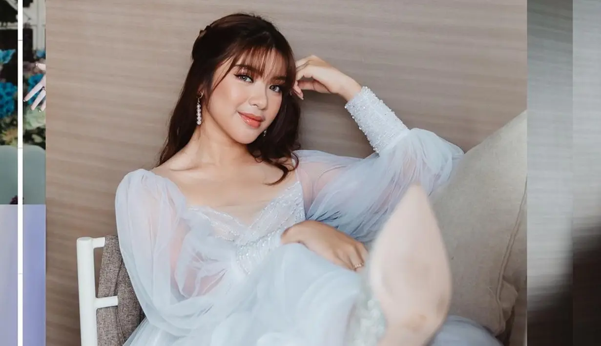 Penyanyi jebolan ajang pencarian bakat menyanyi Indonesian Idol ini memang sering tampil memesona dalam balutan gaun simple. Seperti kali ini, Tiara Andini tampak anggung dengan gaun putih dengan model simple. (Liputan6.com/IG/@tiaraandini)