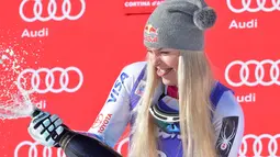 Lindsey Vonn dari Amerika Serikat menyemprotkan sampanye saat merayakan kemenangannya pada kompetisi FIS Alpine World Cup Women's Downhill di Cortina d'Ampezzo, Pegunungan Alpen Italia (20/1). (AFP Photo/Tiziana Fabi)
