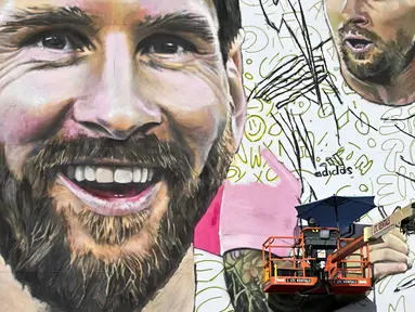 Seniman Argentina, Maximiliano Bagnasco sedang mengerjakan mural besar bergambar Lionel Messi di Wynwood, Miami, 10 Juli 2023. La Pulga akan melakukan debutnya di Inter Miami pada 21 Juli di Piala Liga. (AFP/Chandan Khanna)