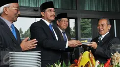 Ketua Mahkamah Agung Hatta Ali (tengah) memberikan potongan tumpeng ke hakim tertua di Mahkamah Agung seusai upacara peringatan HUT Mahkamah Agung ke-70 di Jakarta, Rabu (19/8/2015). (Liputan6.com/Herman Zakharia)